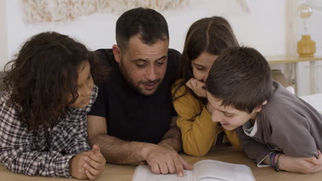 Kaukasischer-Vater-überprüft-Hausaufgaben-Mit-Kindern.